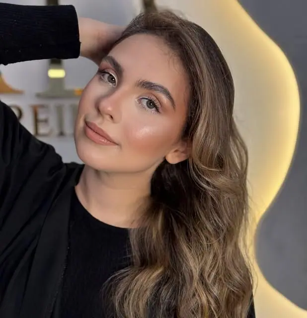Cliente com maquiagem iluminada e cabelo em ondas feitos no TAD
